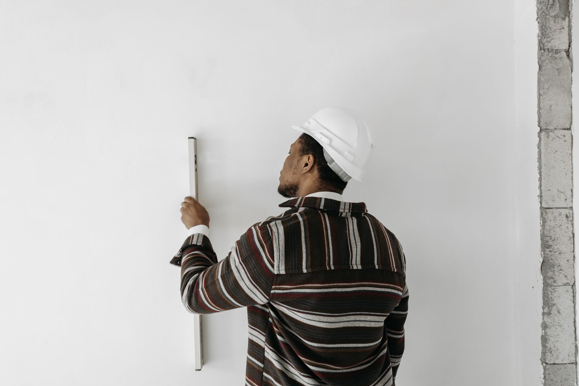 Homme qui vérifie un mur avec un niveau