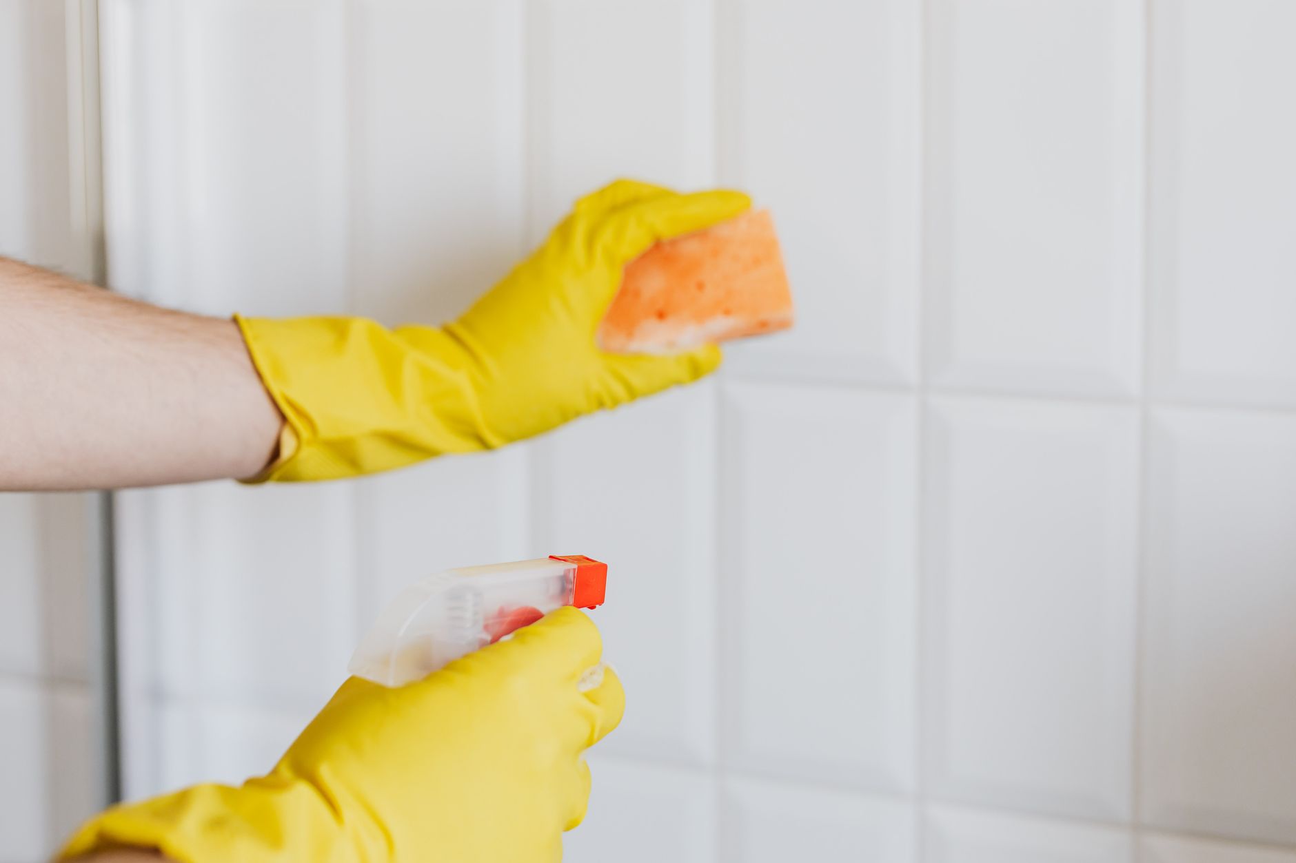 Nettoyage d’un carrelage blanc avec des gants