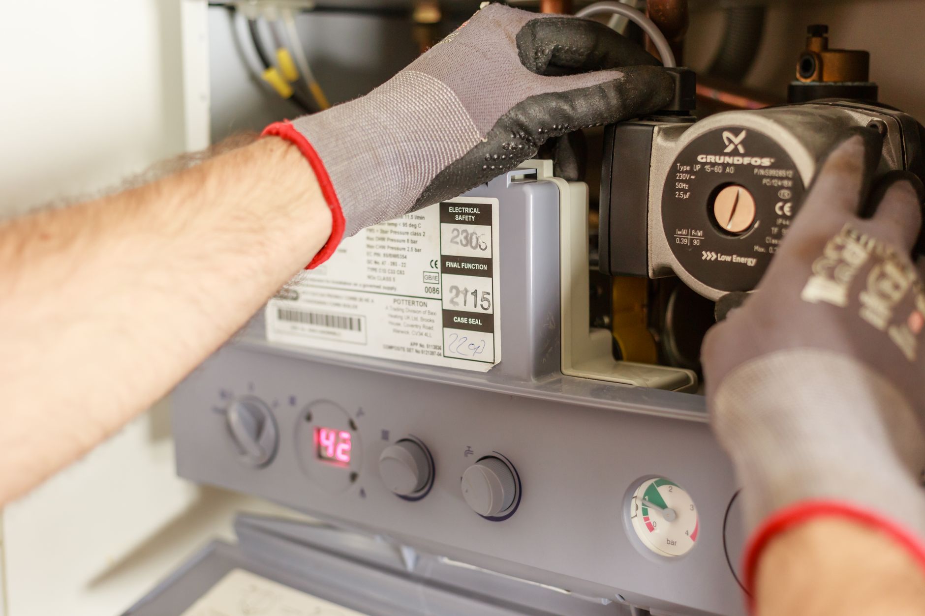 Mains qui règlent une chaudière de chauffage central