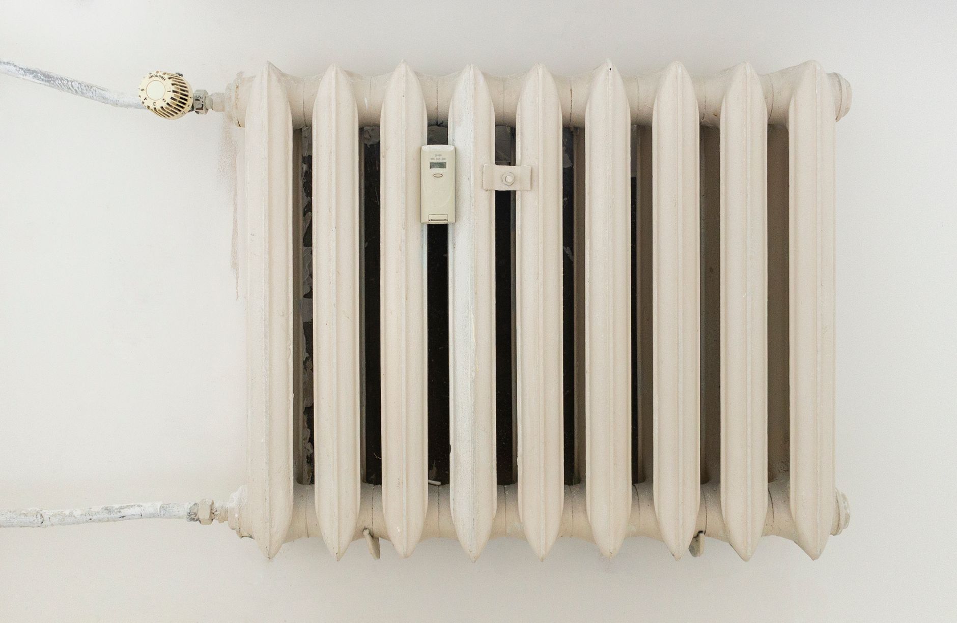 Radiateur blanc en fonte sur un mur uni
