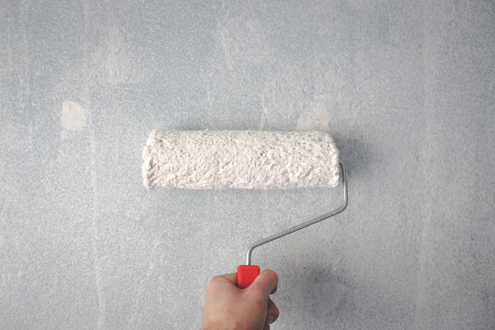 Rouleau de peinture sur un mur intérieur