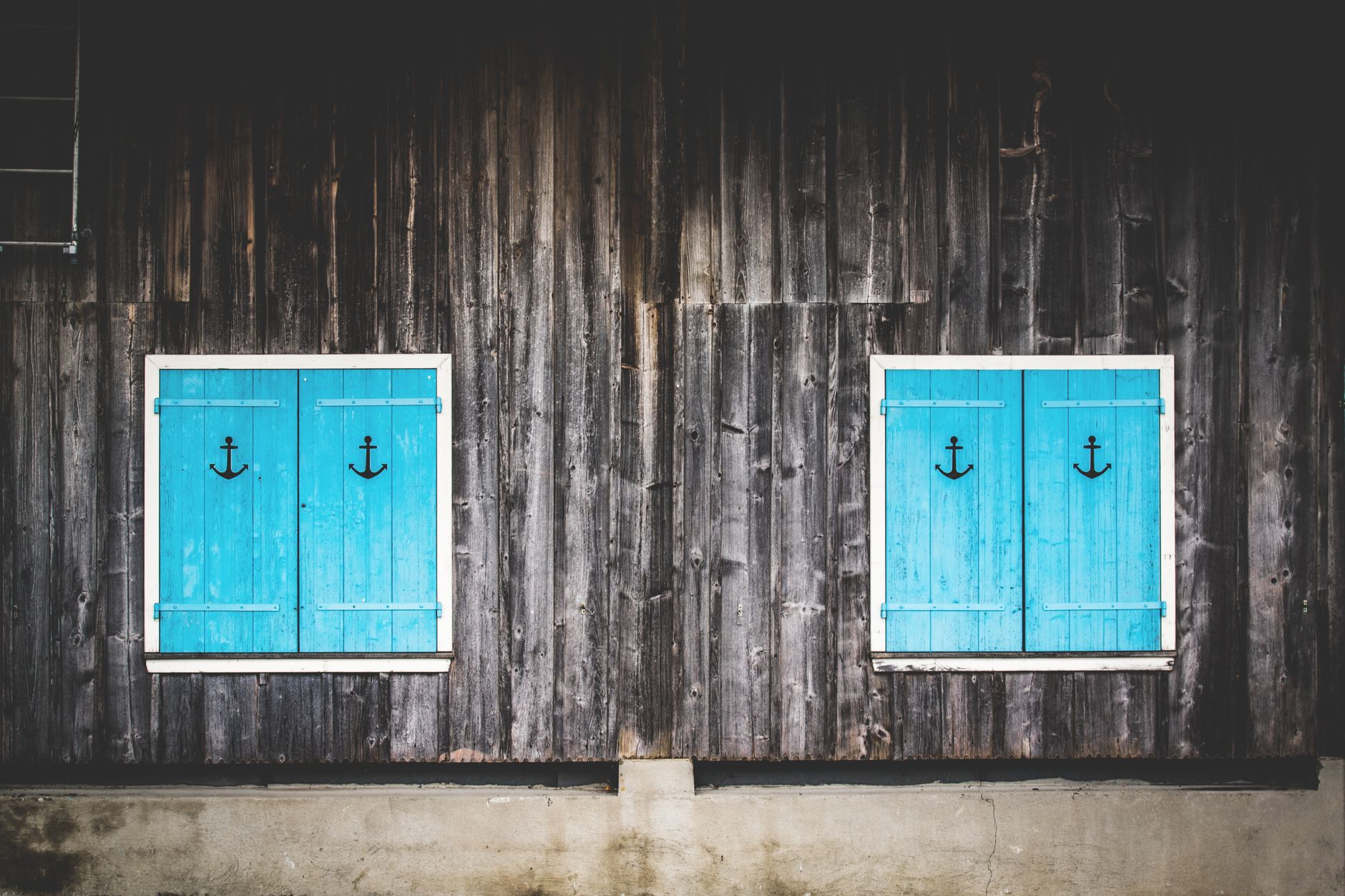 Façade avec deux volets battants en bois turquoise